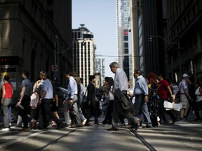Pedestrians cross a street in Toronto's Financial District.